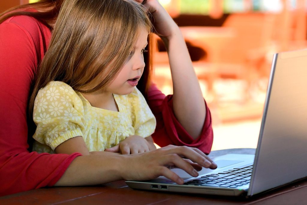 Un enfant et sa mère en train de consulter un ordinateur